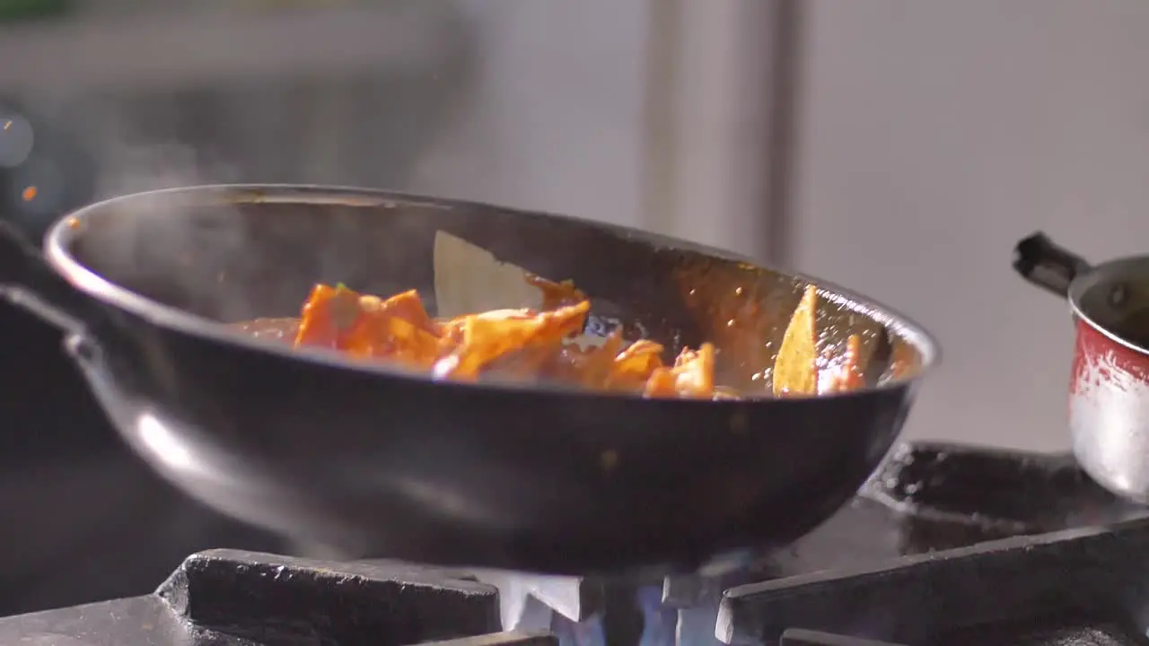 Tortilla chips with hot salsa in frying pan on burning fire in slow motion