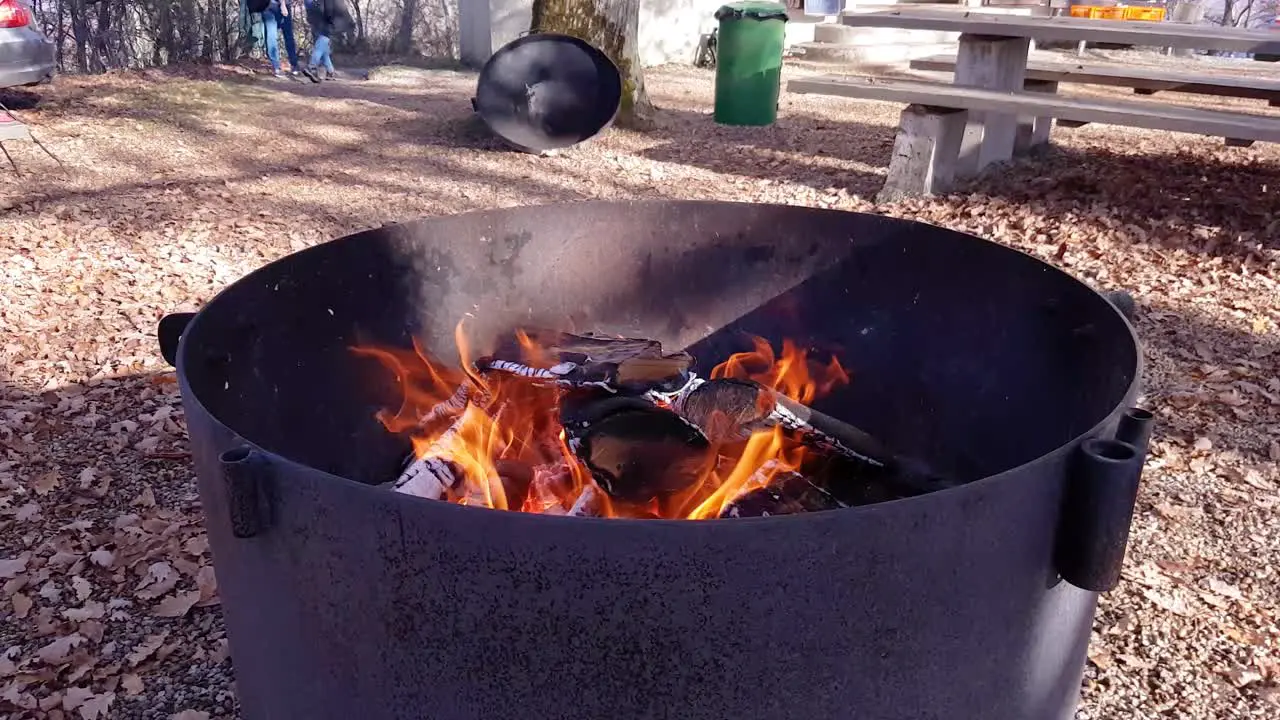 Close-up rotating around daytime campfire outdoors with open flame