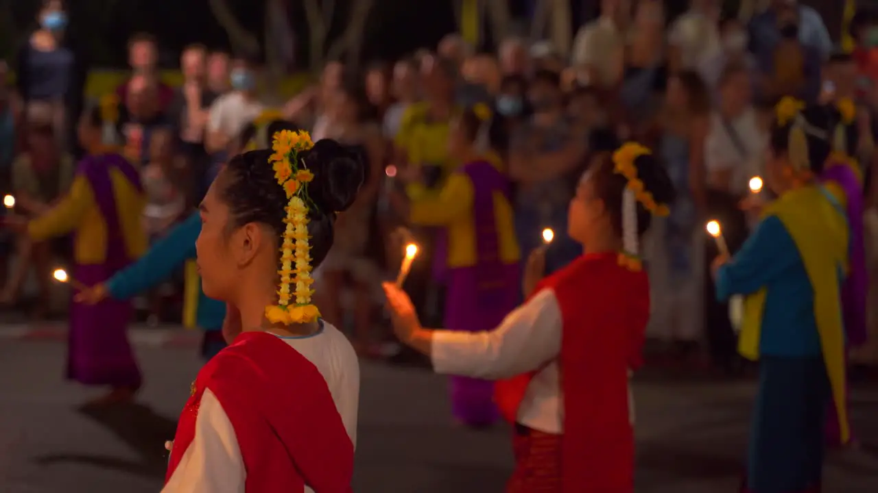 Group of traditional Thai female dancers performing traditional dance with candles