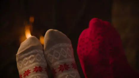 Extreme Close Up Shot of Couples Feet In Front of Burning Fireplace