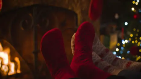 Close Up Shot of Couples Feet In Front of Cosy Burning Fireplace