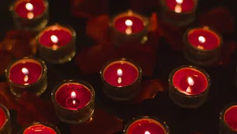 Romantic Lit Red Candles On Background Covered In Rose Petals 1