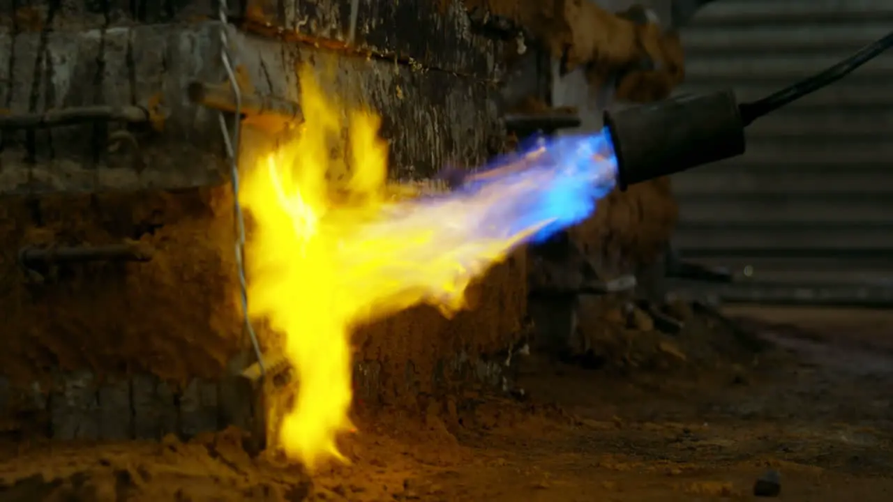 Close-up of metal mold heating with blow torch in foundry workshop 4k