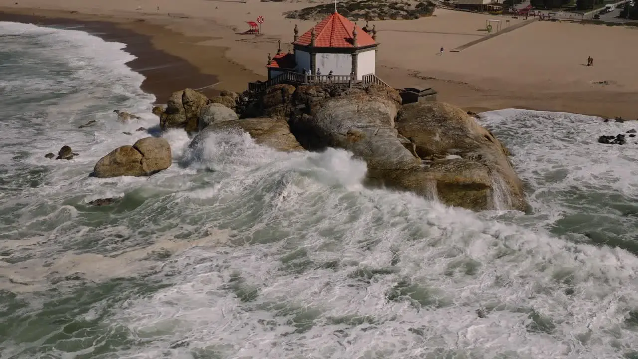 Slow motion of the waves hitting the chapel on the beach