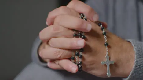 Close Up Shot of Senior Mans Hands Holding Rosary Beads