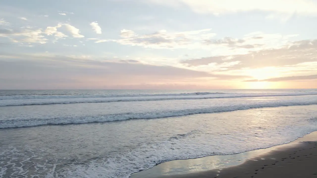 Birds eye view over the waves landing on a beach of the pacific ocean in costa rica at sunset