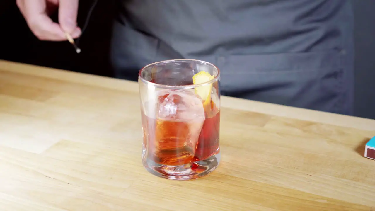 Garnishing a negroni with a flamed orange zest