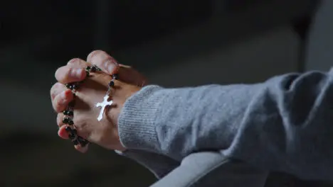 Pull Focus Shot of a Senior Mans Hands Holding Some Rosary Beads