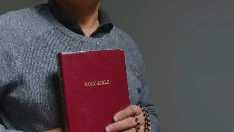 Pedestal Shot of Senior Man Praying with Holy Bible