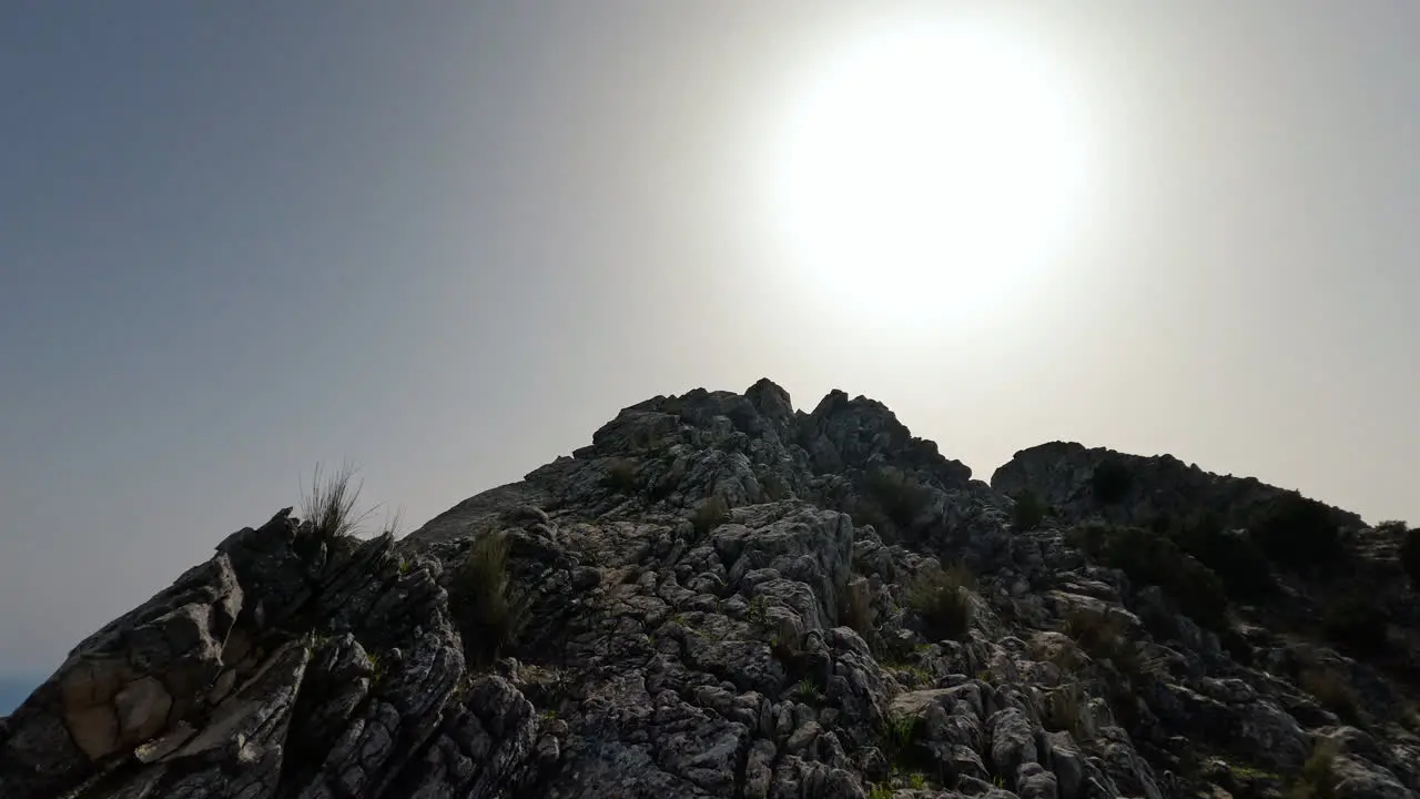 4k Moving shot of a hiker walking up a rocky mountainat La Concha Marbella Spain on a sunny day