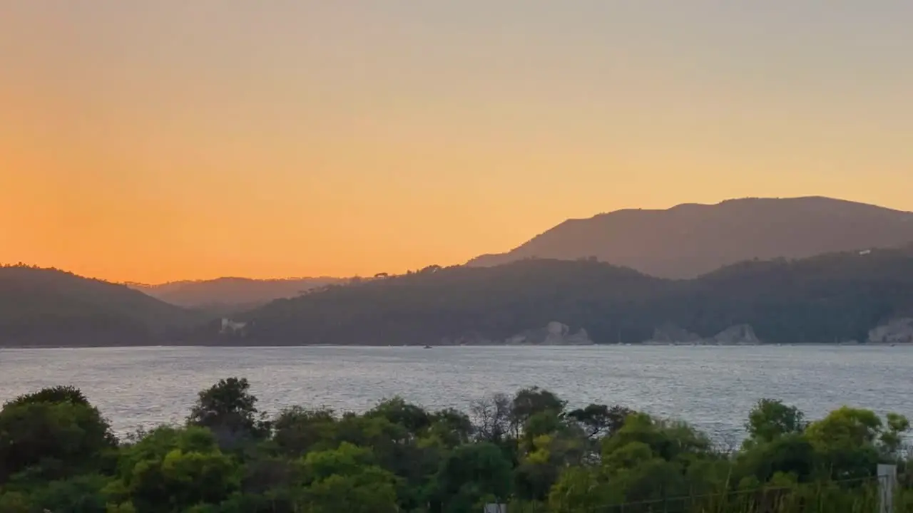 An excellent aerial shot of the sun setting over the Green Mountains and some seagulls flying in Portugal