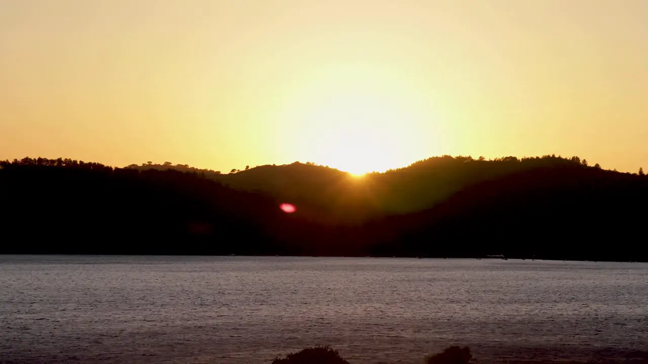 Time lapse bright orange sunset sun sets behind the mountains