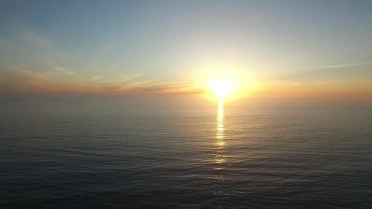 A beautiful aerial above a golden sunset over a generic ocean coast