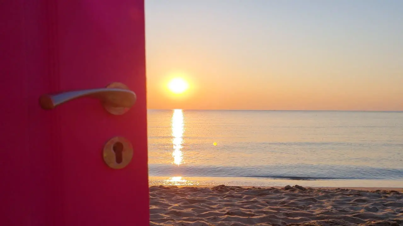 View through an open door to the ocean and sandy beach at sunrise-1