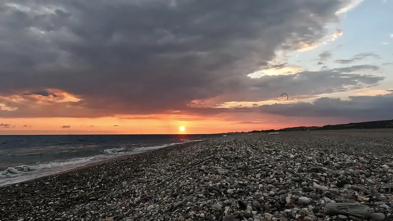 Person raising a surfing kite on the beach