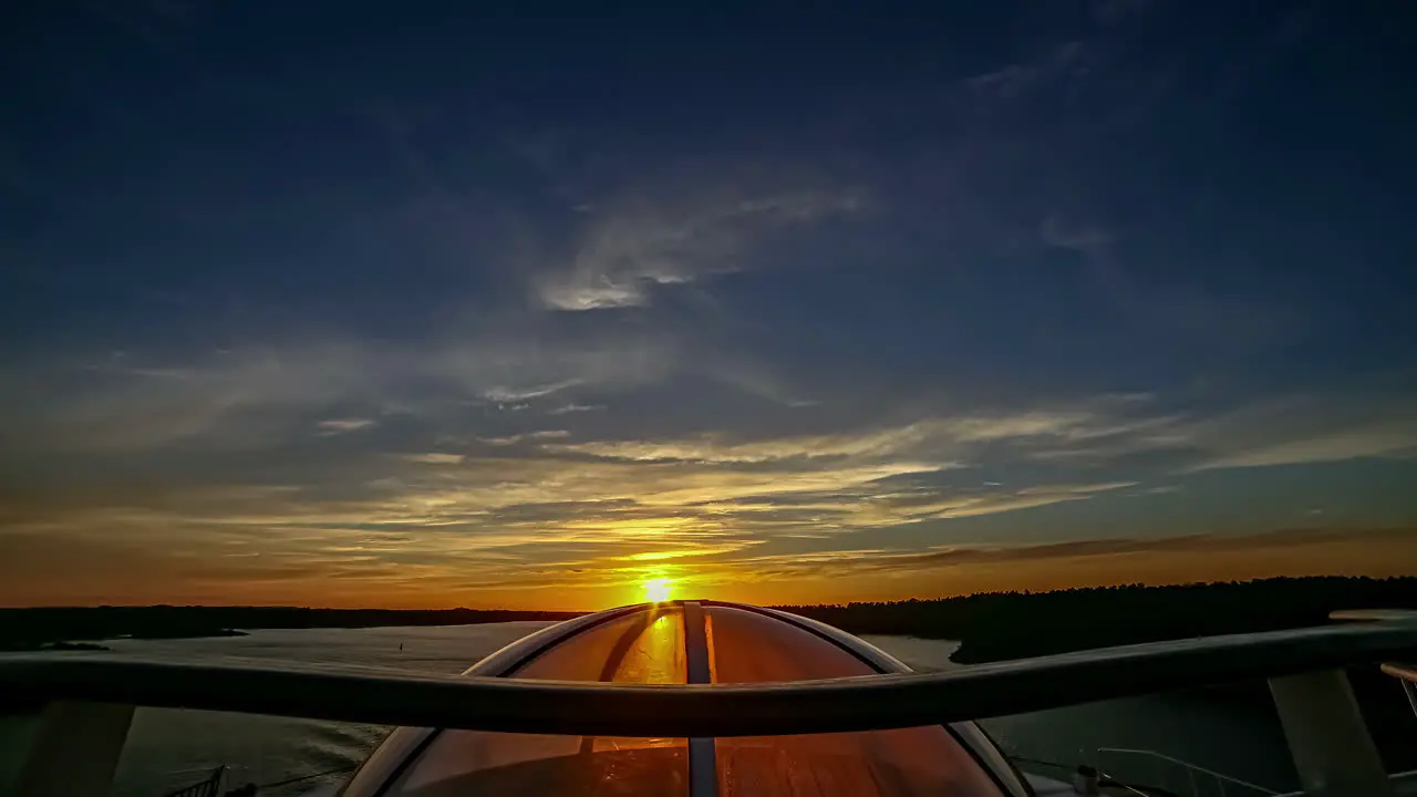 Golden sunset shinning through the glass dome window on a ferry hyper lapse from a boat an inlet of fjord