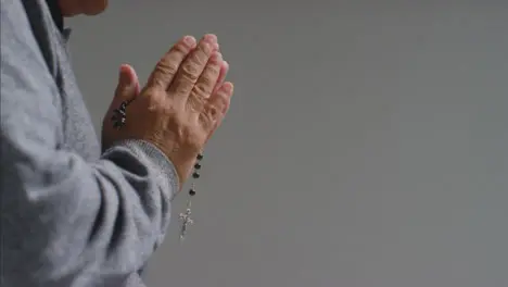 Close Up Shot of Senior Mans Hands Holding Some Rosary Beads with Copy Space