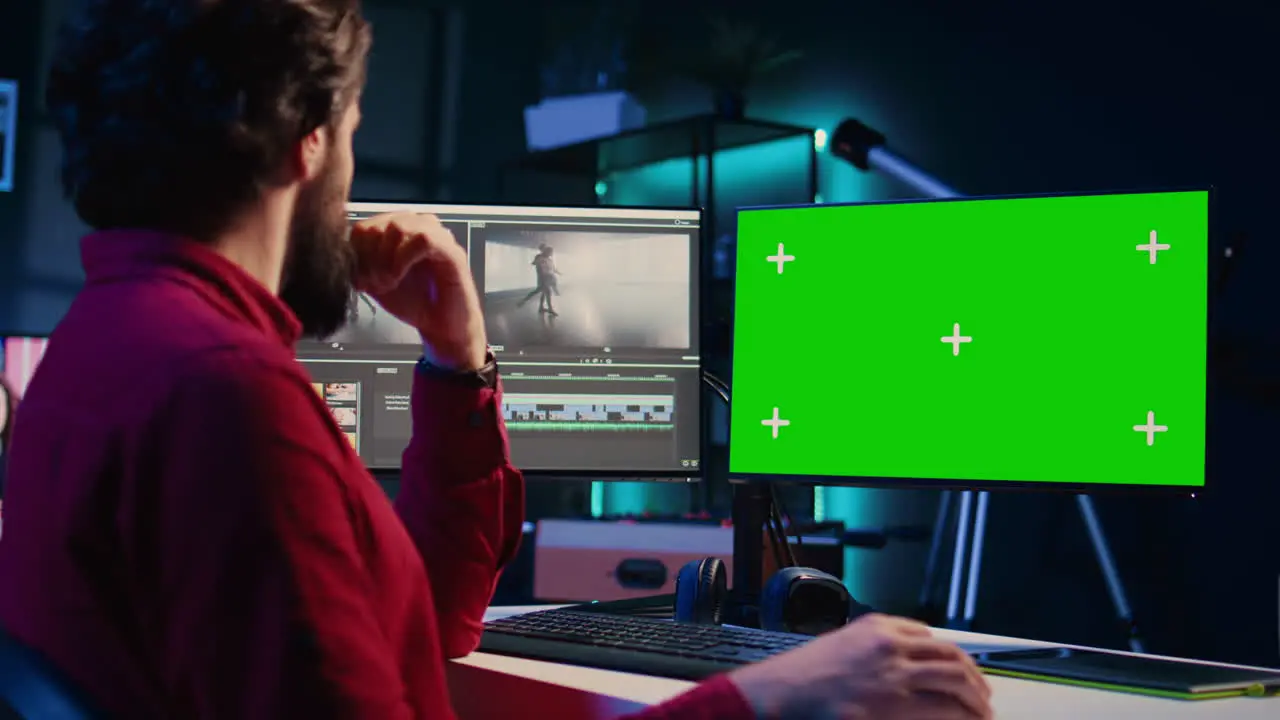 Post production studio employee working with raw footage on chroma key PC