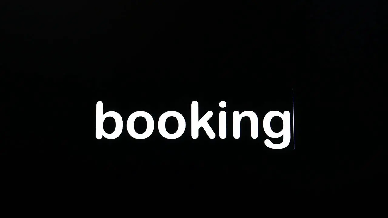 Writing on the screen with a flashing paragraph forming the word booking in white on a black background