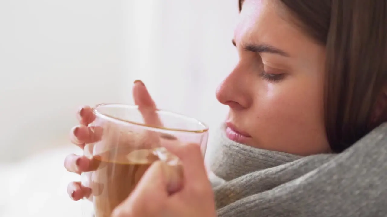 sick girl lying in bed drinking tea girl coughs and colds