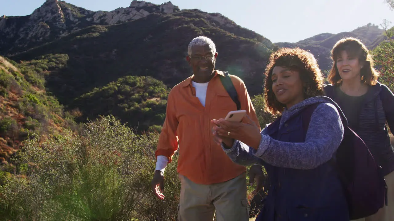 Group Of Senior Friends Posing For Selfie As They Hike Along Trail In Countryside Together