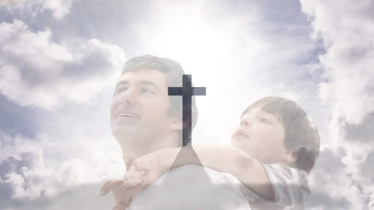 Animation of crucifix cross monument and cloudy sky over caucasian father carrying son