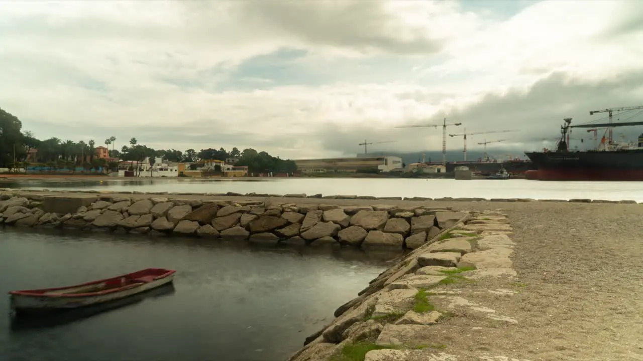 Docked lonely wooden boat with dock building in background time lapse