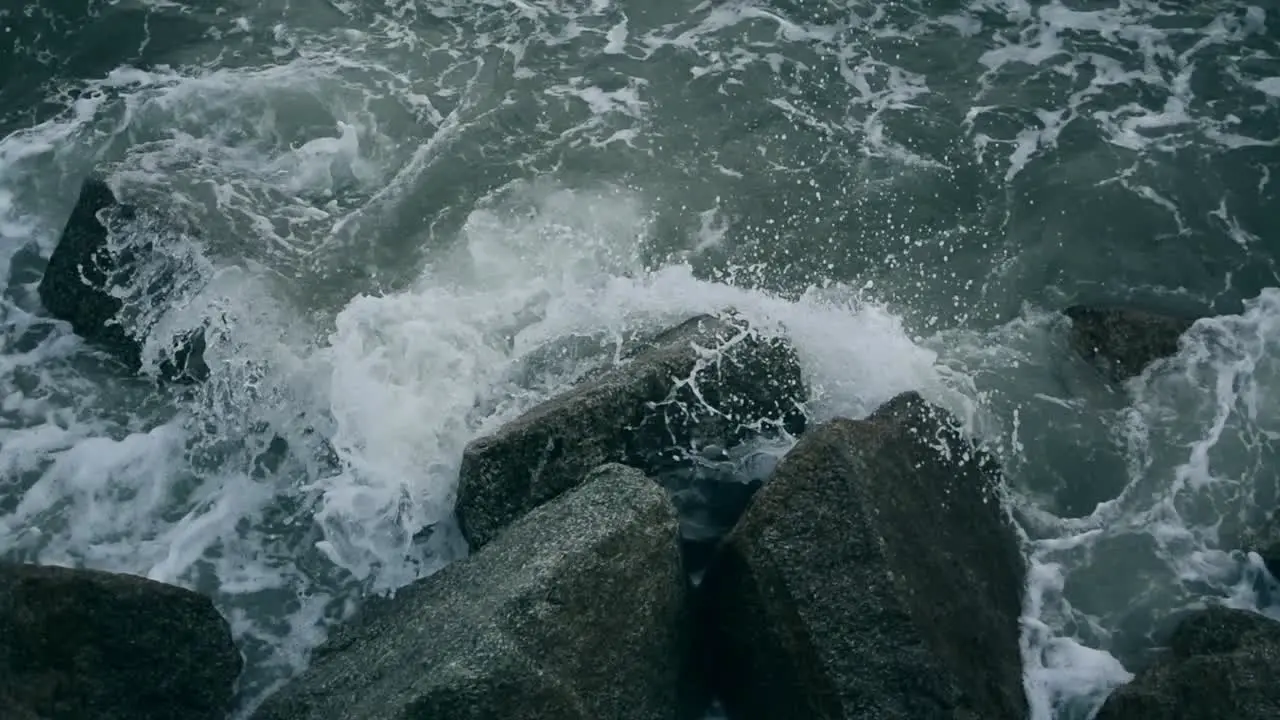 Waves submerging the jagged rocks