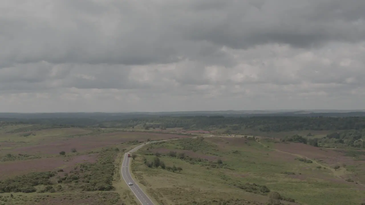 Aerial Drone Shot of English UK Countryside in The New Forest with Road and Cars in moody stormy weather