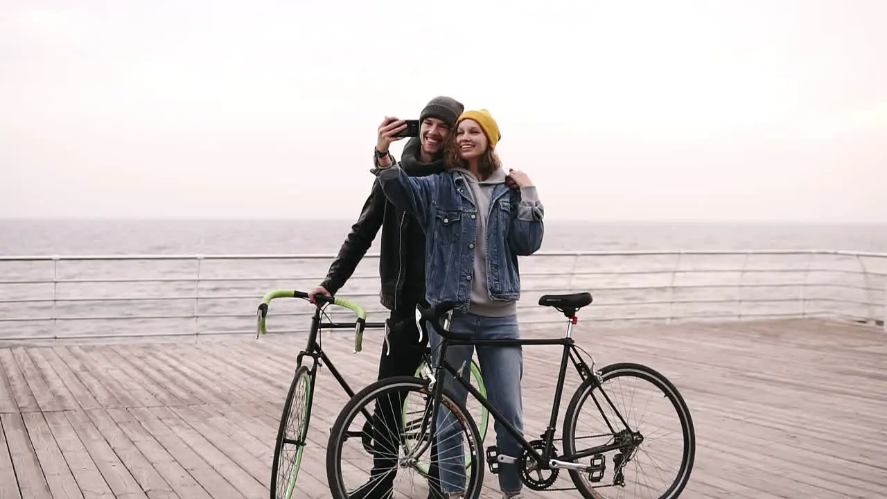 Happy Young Couple Taking Selfie By Mobile Phone Near The Seaside In Cloudy Day 1