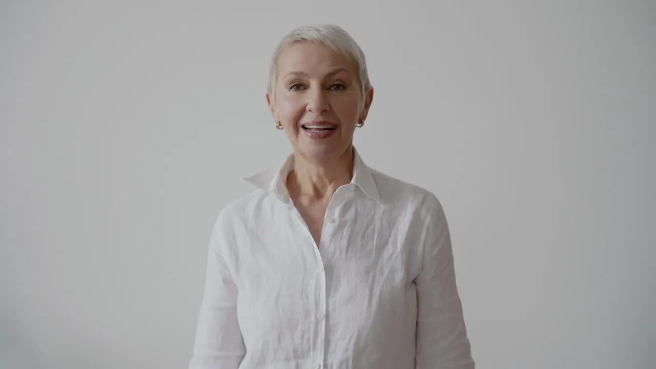 Beautiful Happy Senior Woman Clapping Hands And Cheering While Looking At Camera On White Background