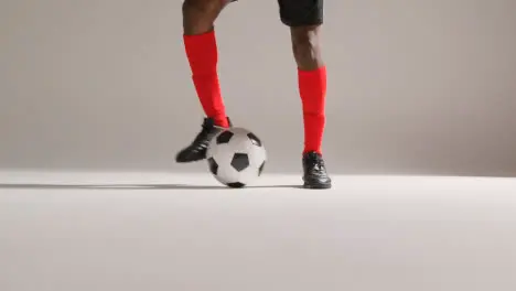 Close Up Of Male Footballer In Studio Controlling And Flicking Ball Into The Air 1