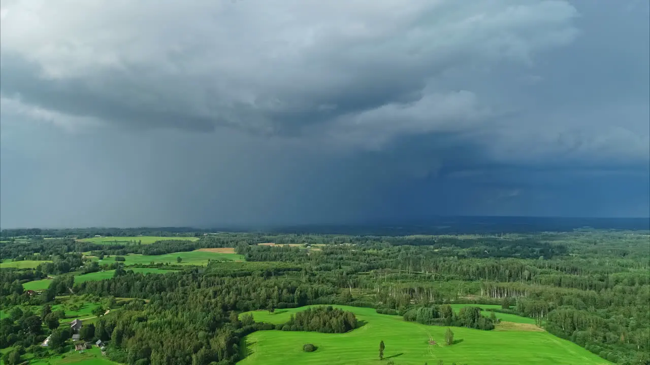 High panoramic aerial view of a green landscape under ominous storm clouds