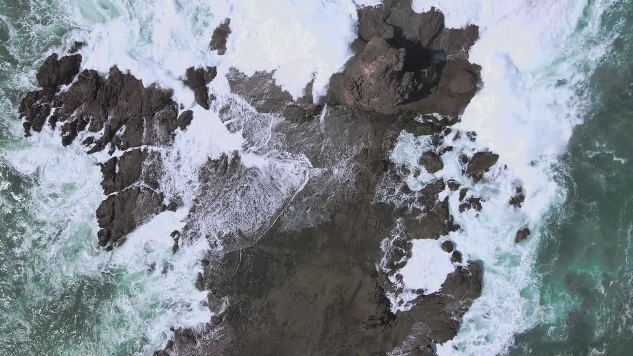 Top down shots of white foamy waves breaking on the rocks on the coast of Indonesia