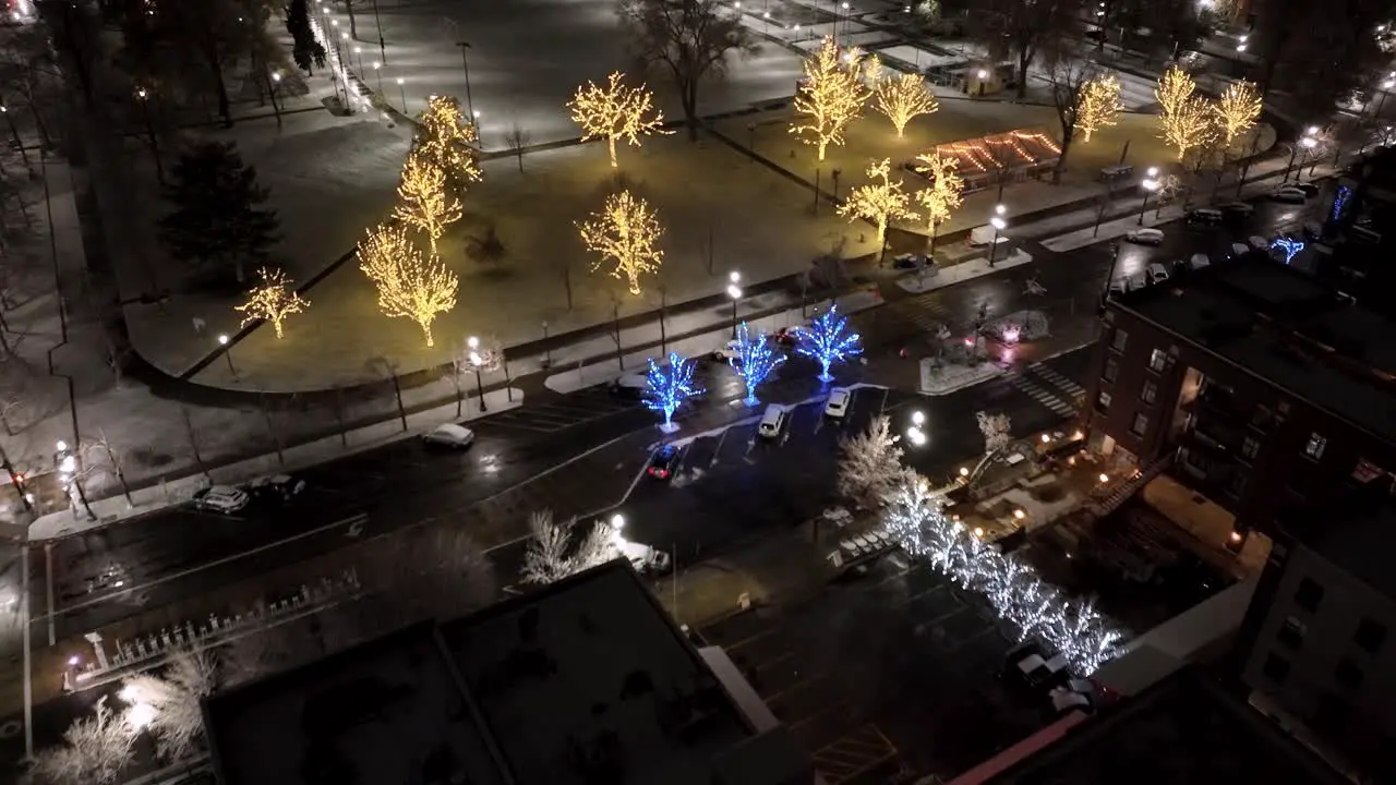 City park decorated with Christmas lights pullback aerial