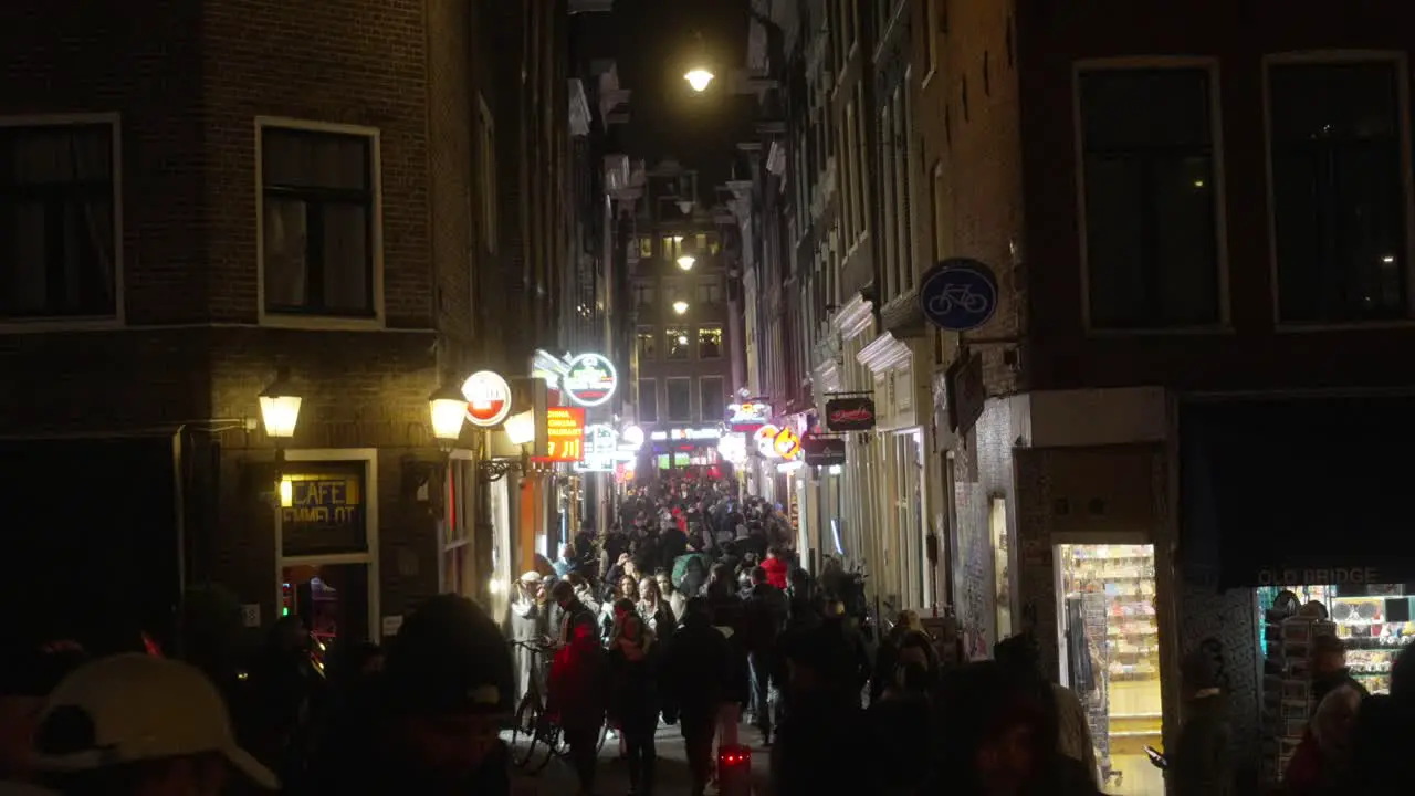 Busy city street near the red light district in Amsterdam tourists and pedestrians walking busy street