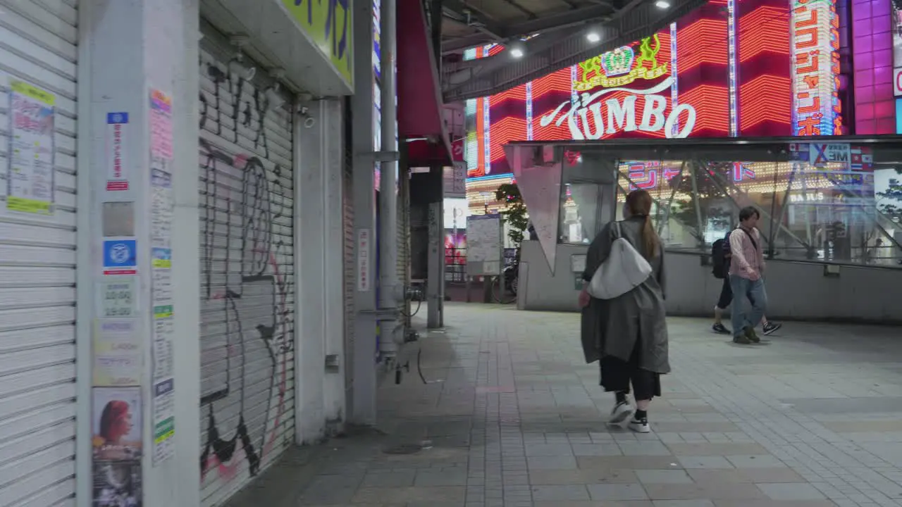 a lonely woman walking through the streets of Shinjuku in Tokyo Japan at night