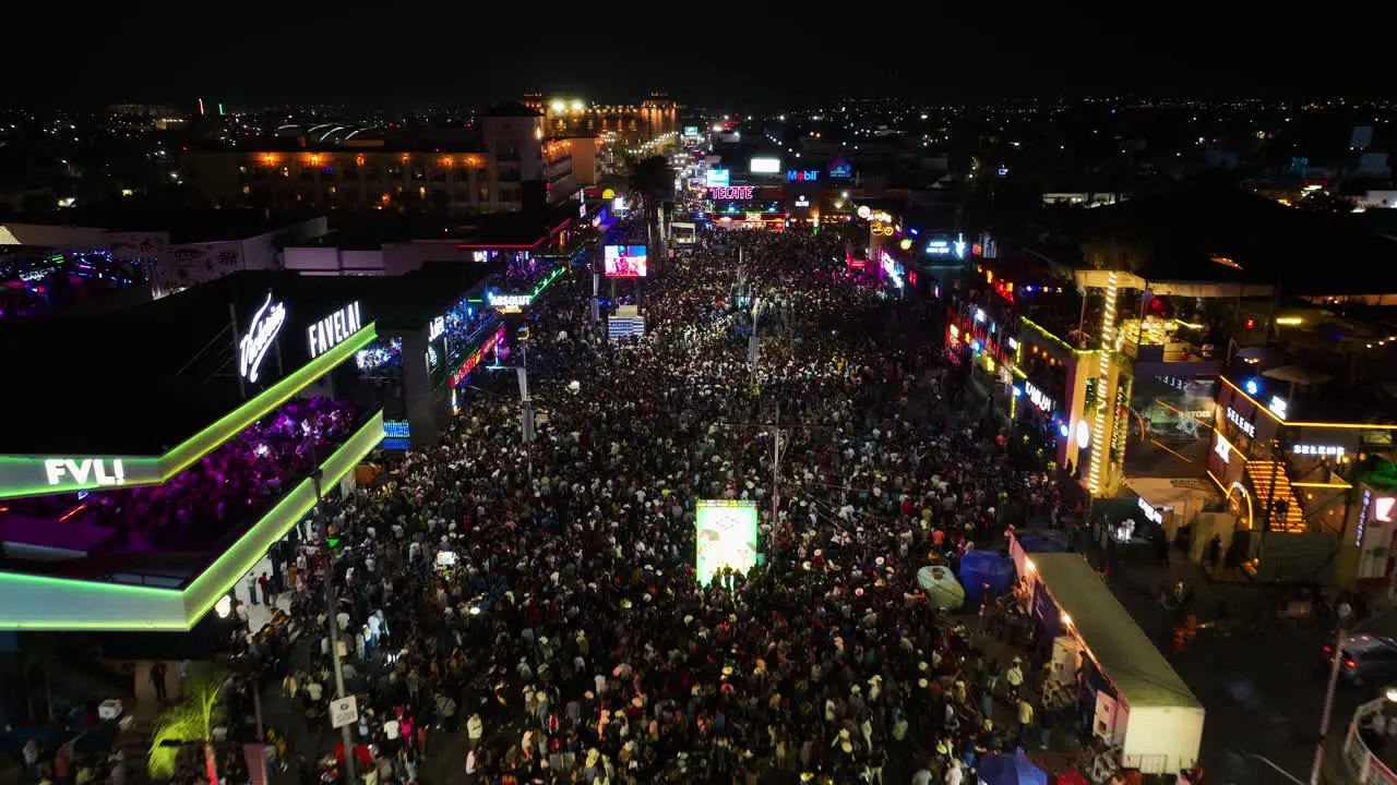 Aerial view over people and colorful lights at the San Marcos fair night in Aguascalientes Mexico