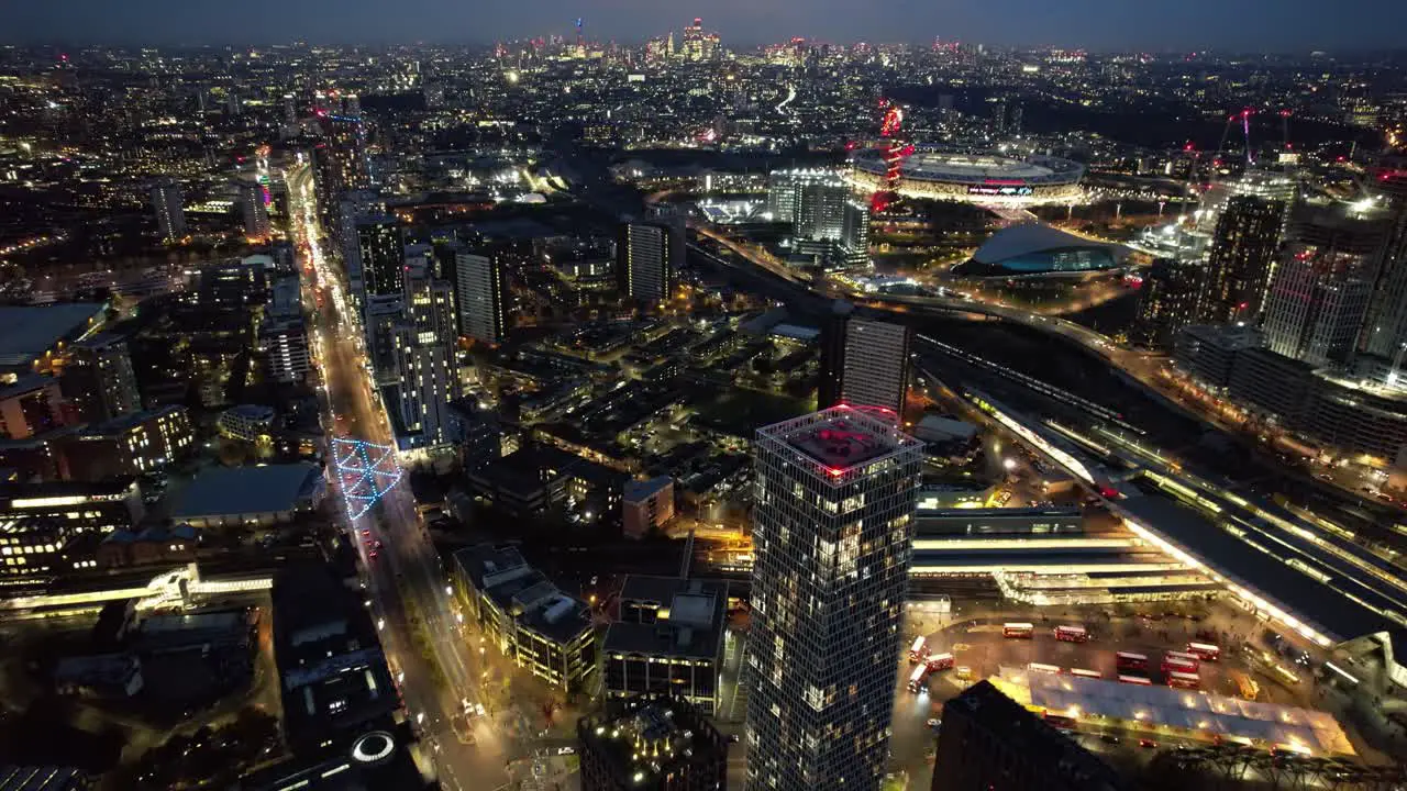 Futuristic Stratford luxury downtown skyscrapers glowing roads at night aerial view slow forward flight