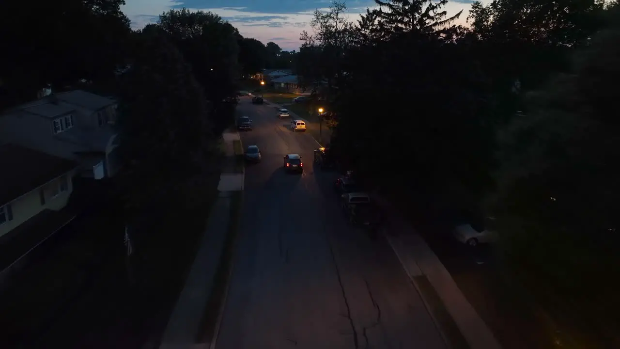 Car driving through small town community at night