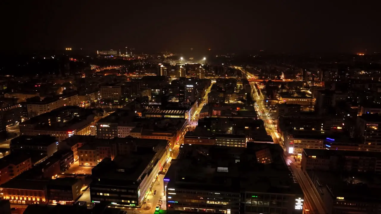 Aerial view rotating over the illuminated downtown Oulu winter night in Finland