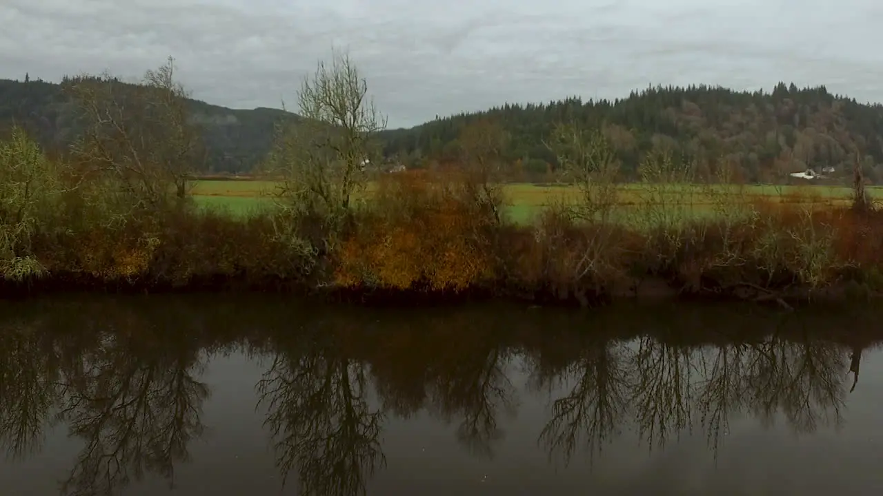 Drone aerial of the Coquille River Valley in Southern Oregon Pacific Northwest and reflections of trees in the water