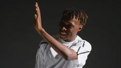 Low Key Studio Portrait Of Young Male Footballer Wearing Club Kit Celebrating Goal 2