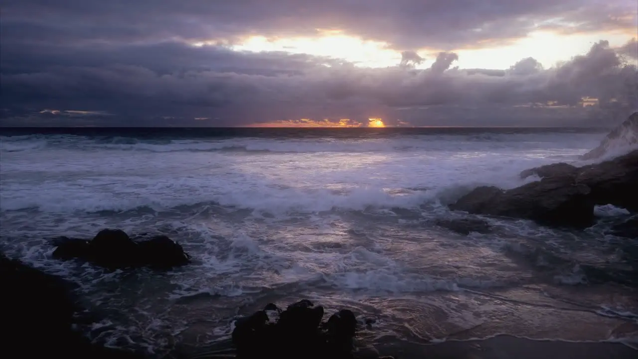 Dramatic seascape view with dark clouds and waves crashing against rocks