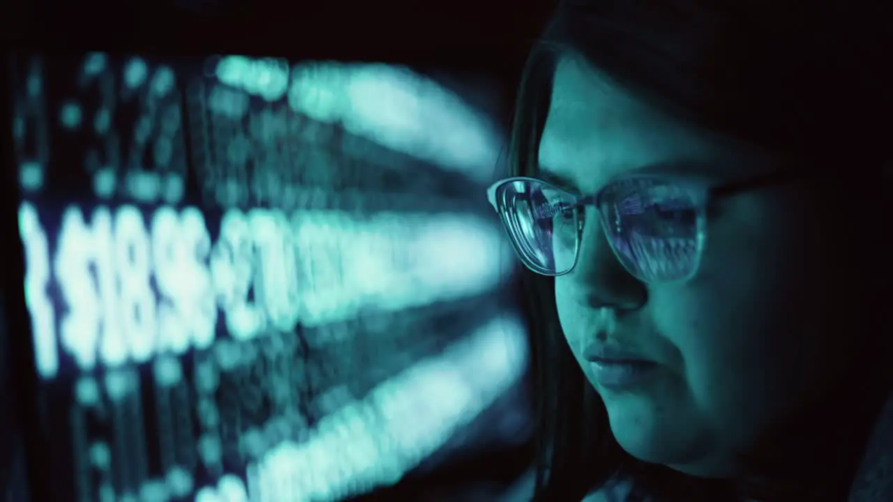 Closeup of Young Adult Female Wearing Reflective Glasses Analyzing Cyber Security Data Code Working at Night Concentrating Computer Screens | Cryptocurrency Financial Virus Hacker Women Programmer 4K