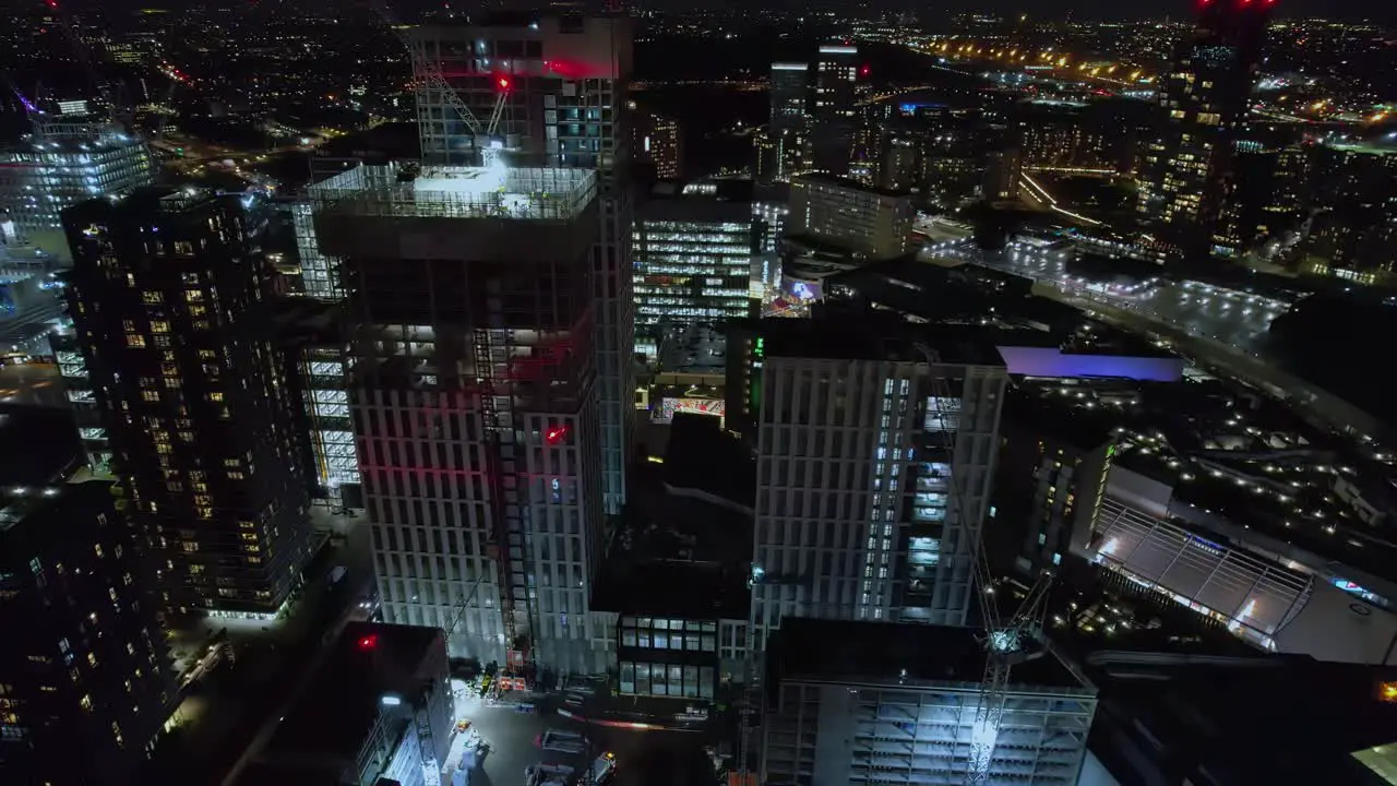 Futuristic Stratford luxury downtown cityscape skyscrapers glowing roads at night aerial view orbit right