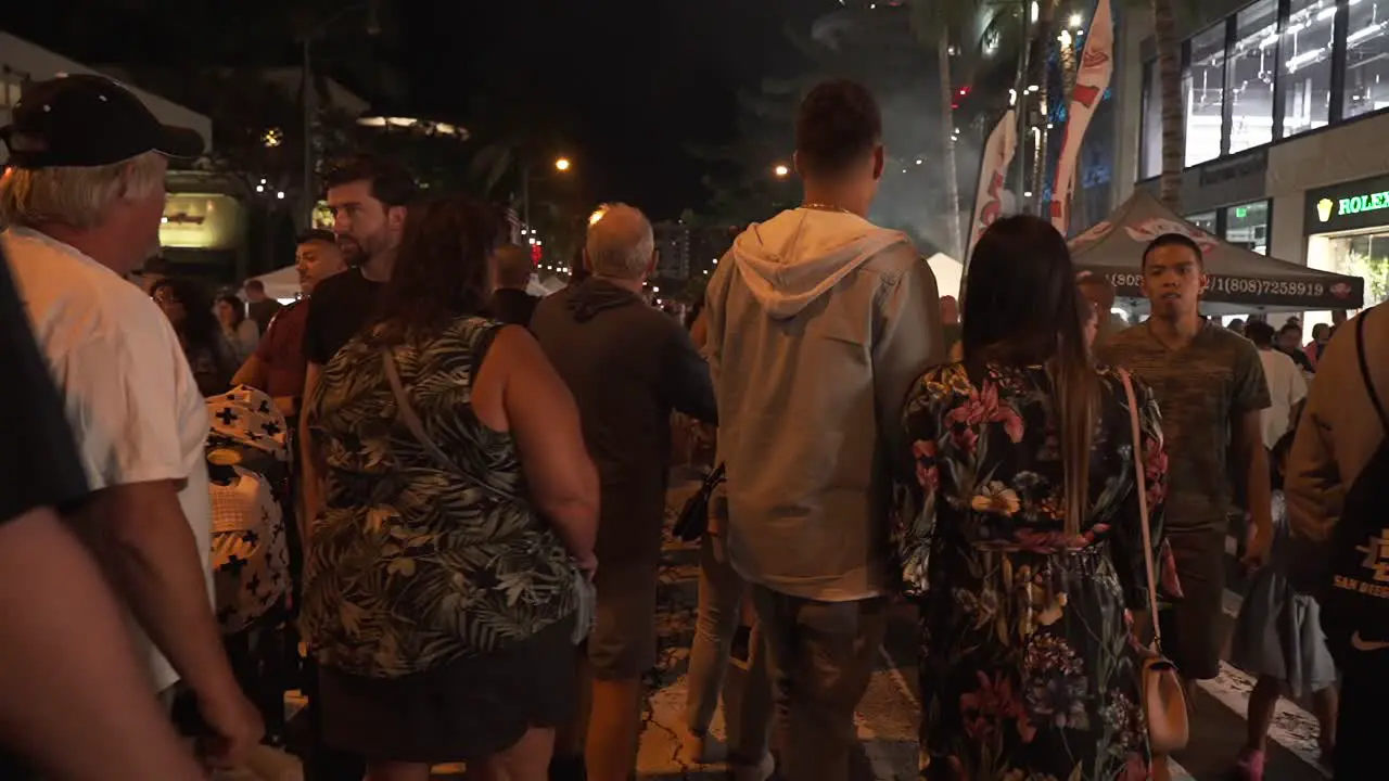 Hawaiian Busy night life on food market street with tourists and natives mingling Medium static shot