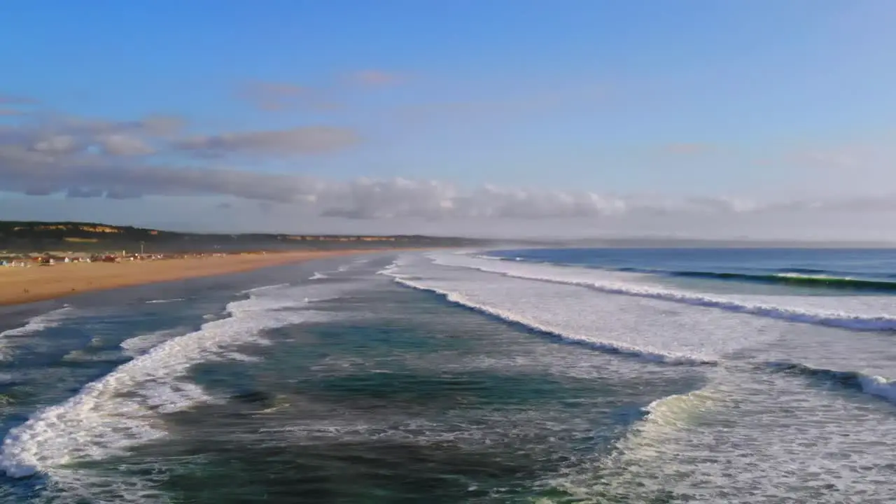 Drone shot filming waves rolling in to a big beach in Portugal 