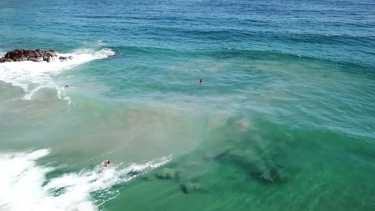 3 surfers waiting for the next big wave to ride on the beaches of Oaxaca in Mexico in the pacific ocean