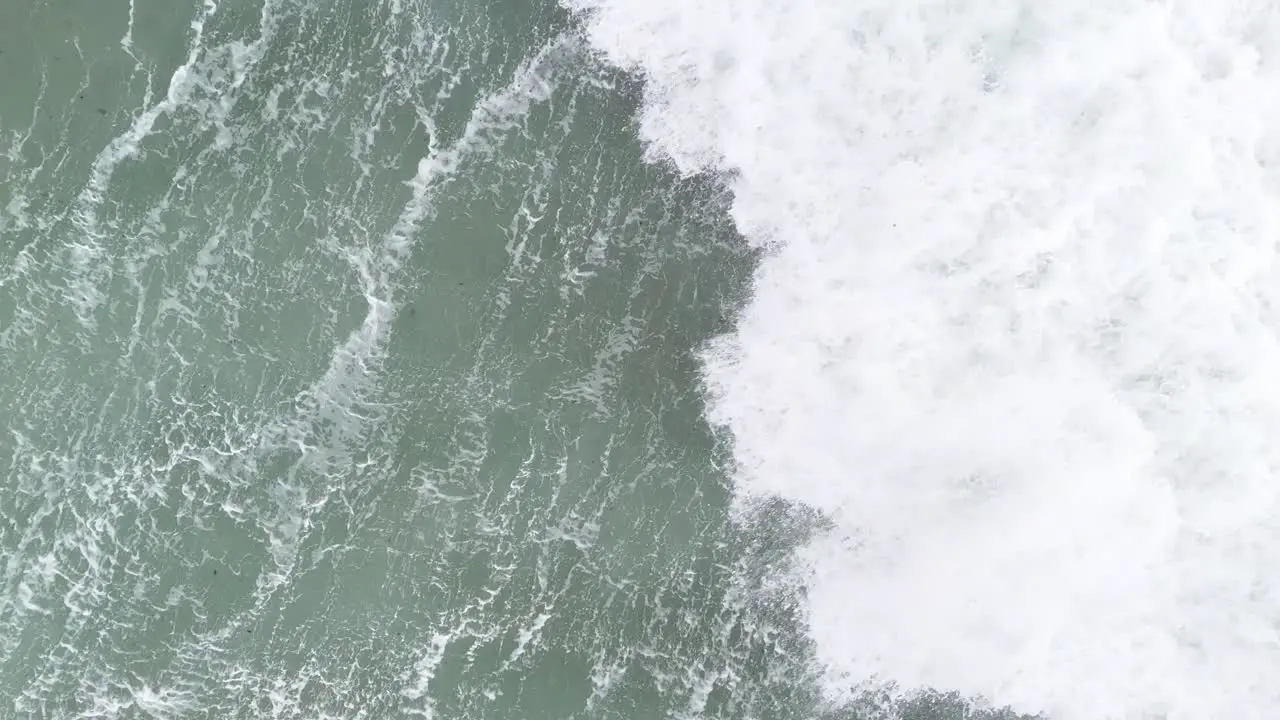 Slow motion wave crashing in sea Overhead birds eye drone aerial view 4K